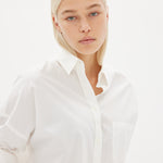 White cotton shirt front view showing relaxed fit and chest pocket detail