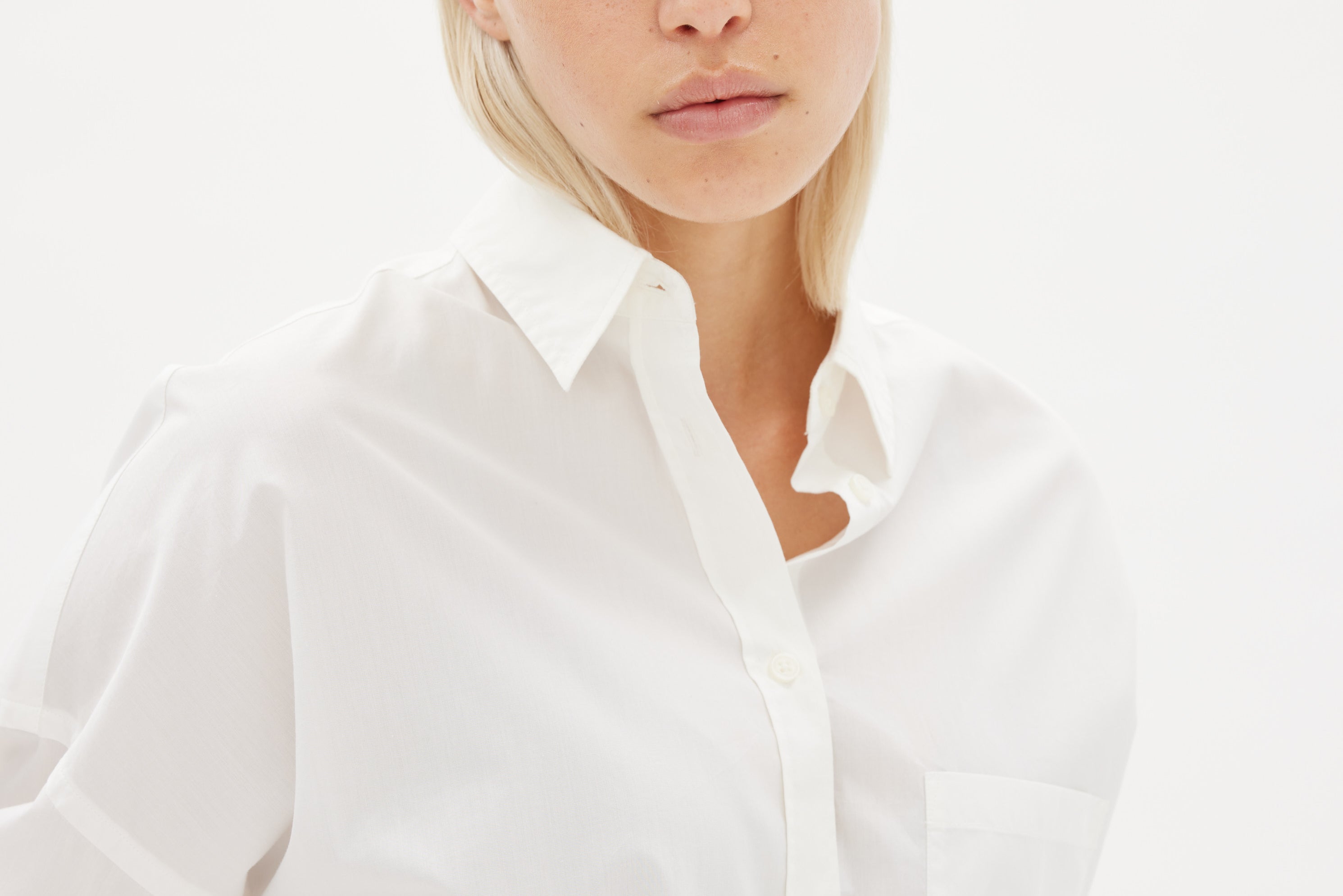 White cotton shirt front view showing relaxed fit and chest pocket detail