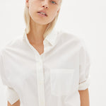 White cotton shirt front view showing relaxed fit and chest pocket detail