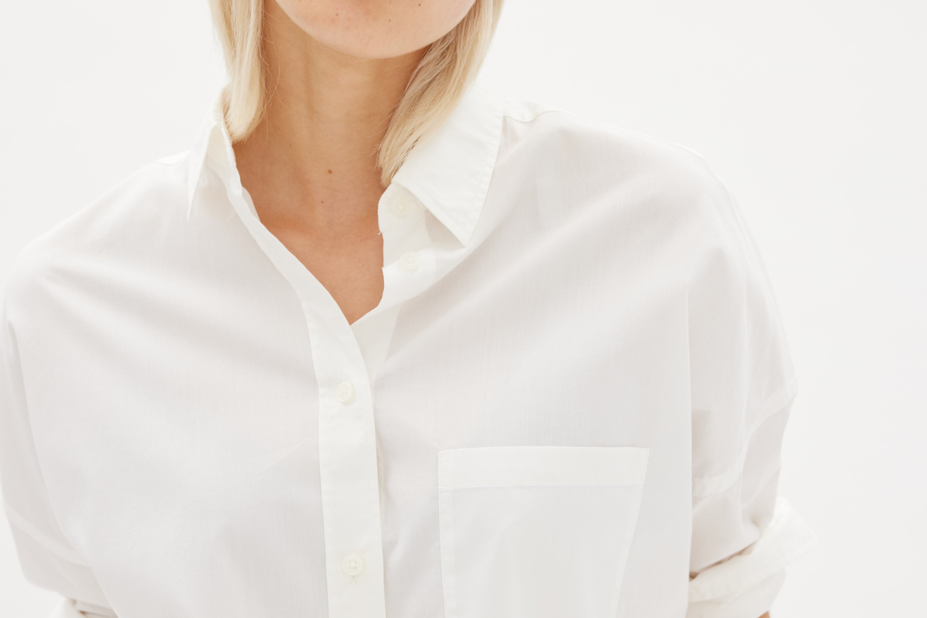 White cotton shirt front view showing relaxed fit and chest pocket detail