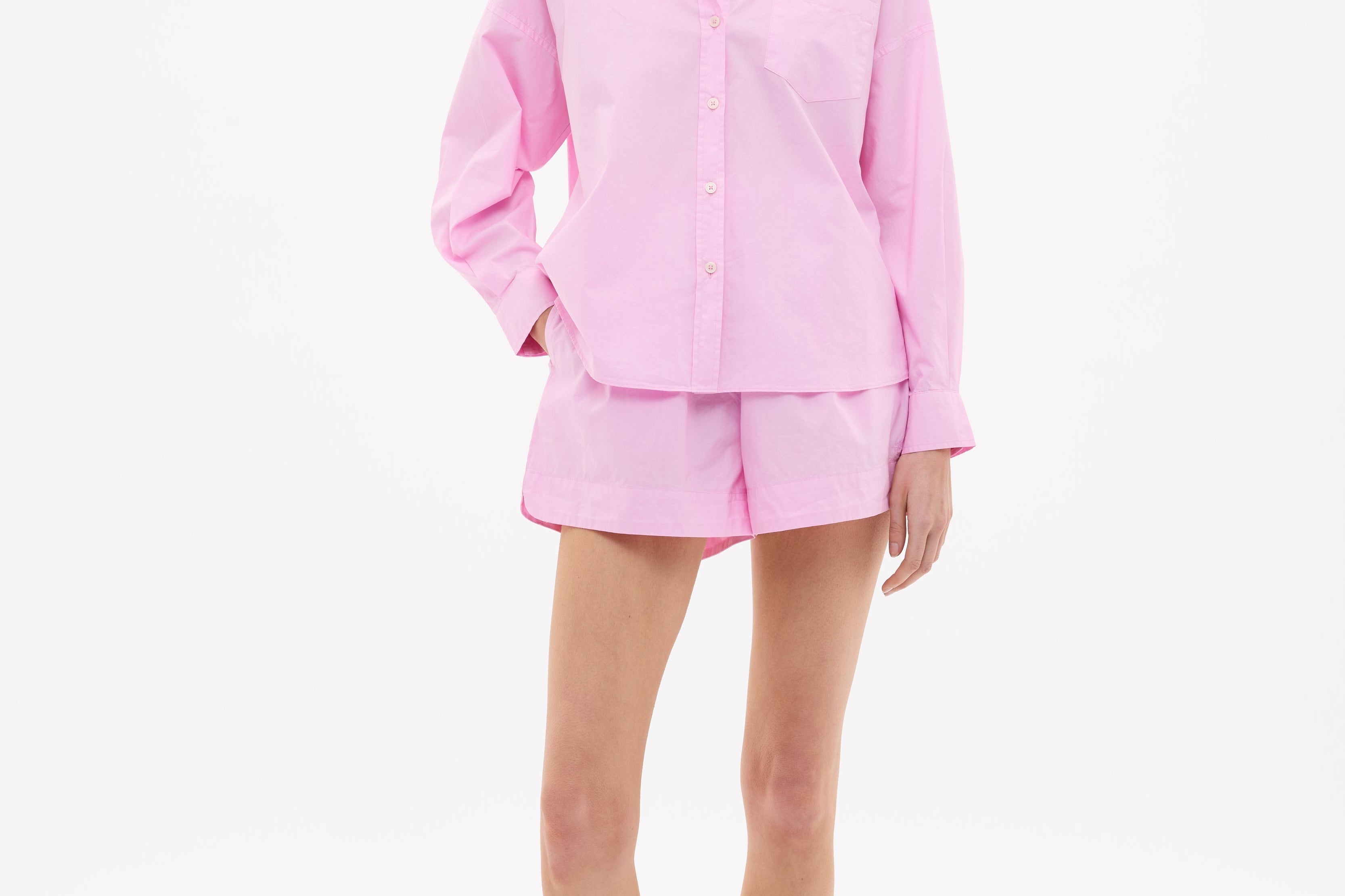 Woman wearing rose glow oversized cotton button-up shirt with chest pocket and drop shoulders