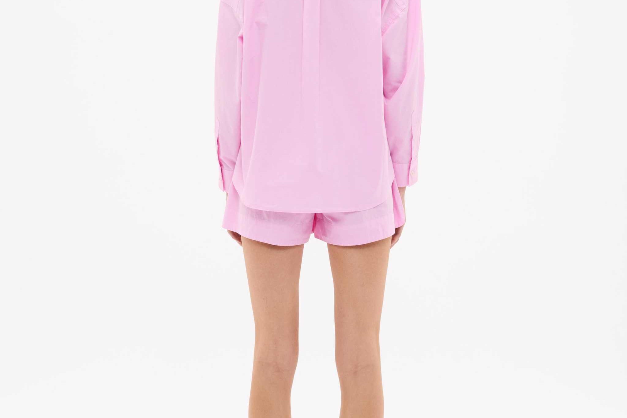 Woman wearing rose glow oversized cotton button-up shirt with chest pocket and drop shoulders