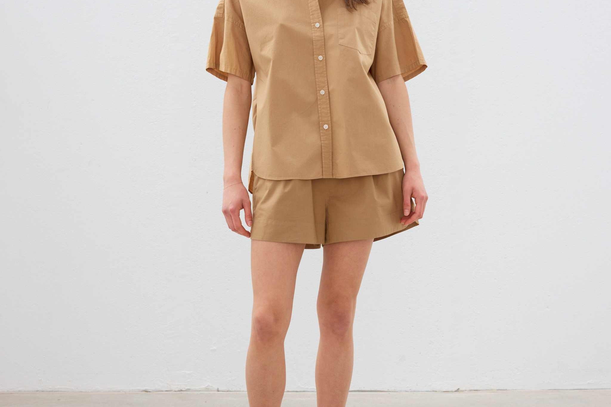 Woman wearing toffee-colored cotton button-up short sleeve shirt and matching shorts in relaxed fit