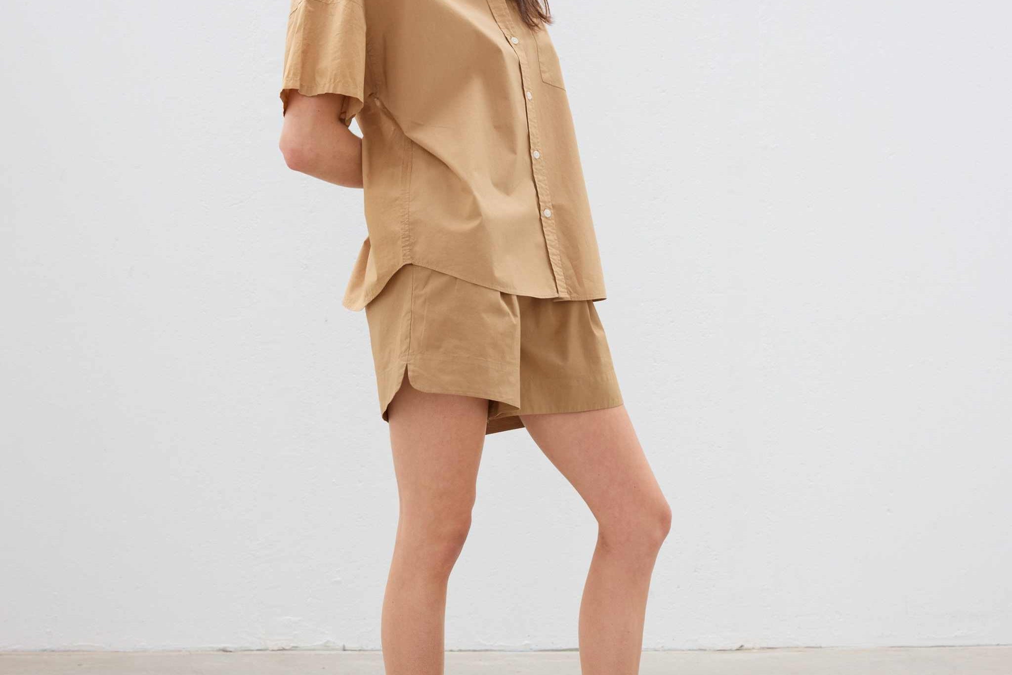 Woman wearing toffee-colored cotton button-up short sleeve shirt and matching shorts in relaxed fit