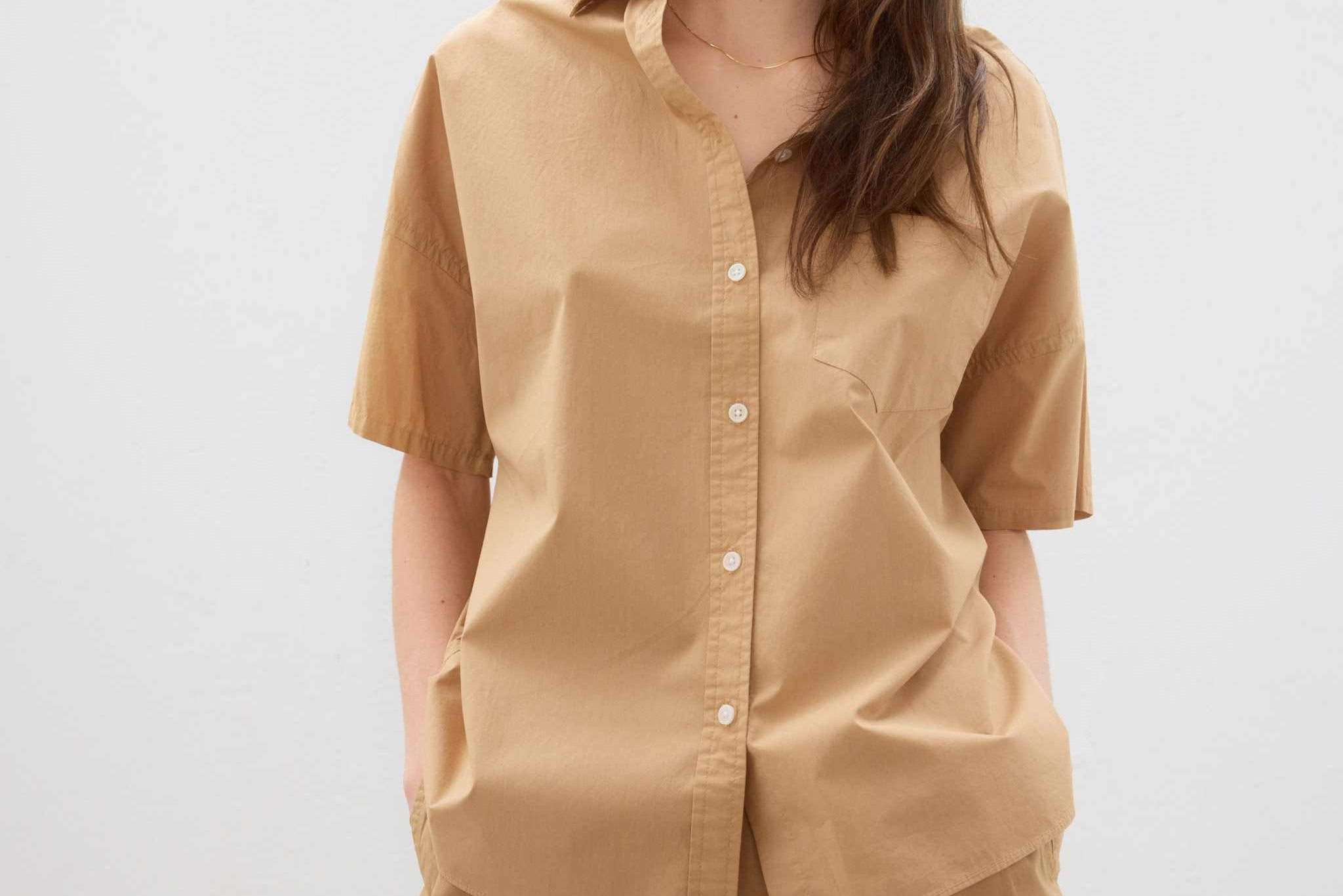 Woman wearing a toffee-colored cotton button-up short sleeve shirt with matching shorts in a relaxed fit